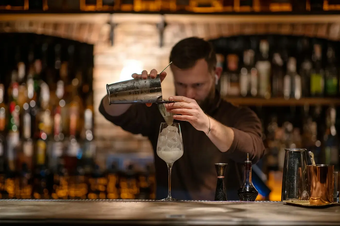 A bartender shaking a cocktail at a busy bar